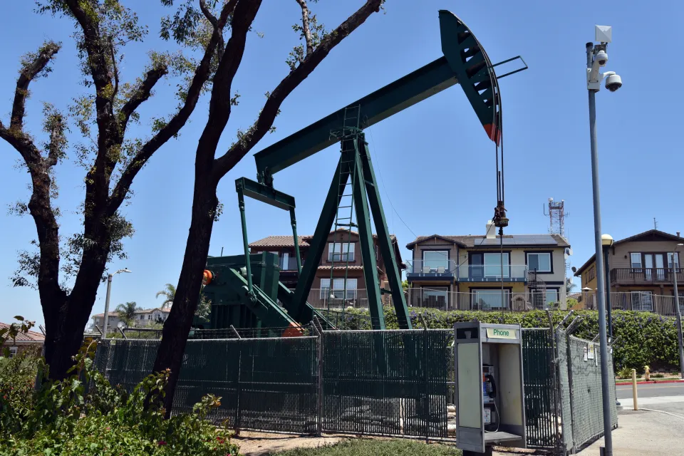 Fenced-in oil pump in residential neighborhood